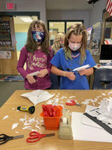 Students cutting out snowflakes
