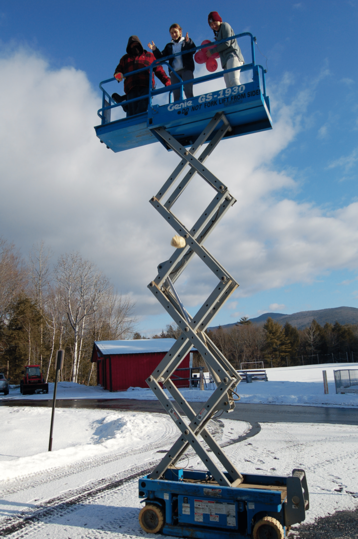 three people up on a scissor lift