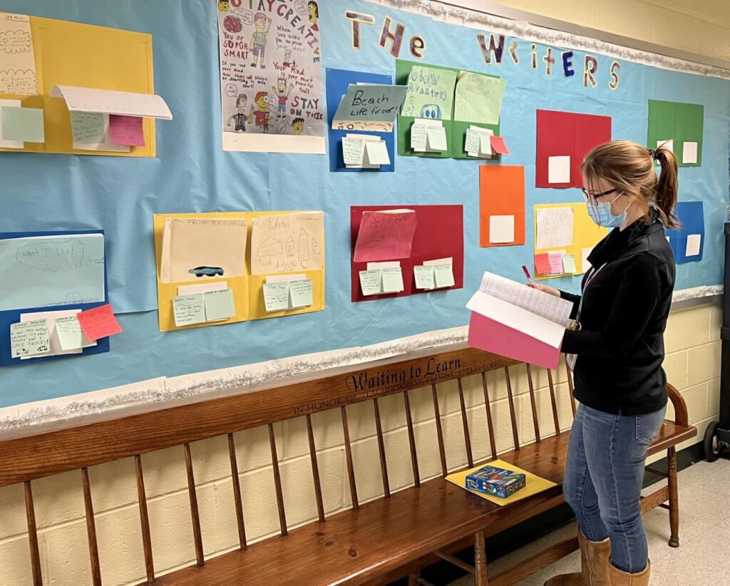 Teacher reading student writing