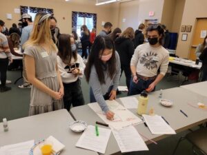 students by a table looking at data