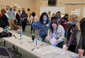 students by a table looking at data