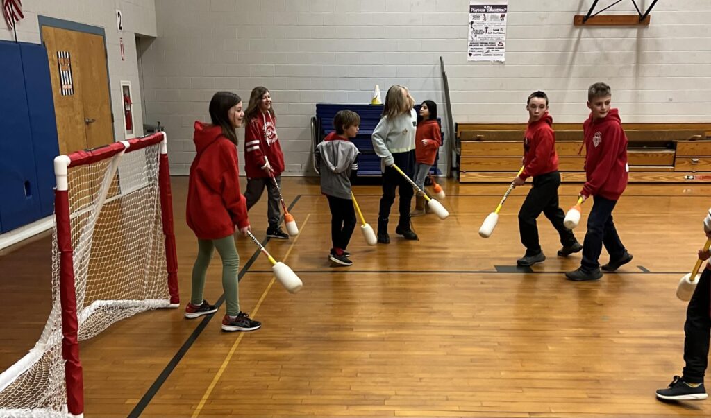 students playing floor hockey