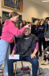 girl shaving a persons head