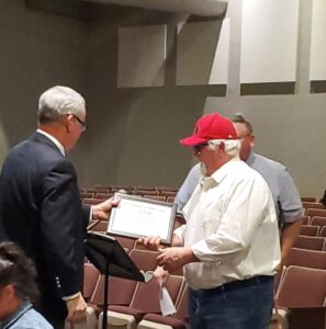 Superintendent Patrick Andrew hands Tim Woods an award
