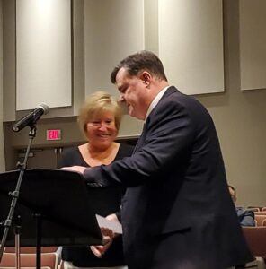 Man hands a woman an award