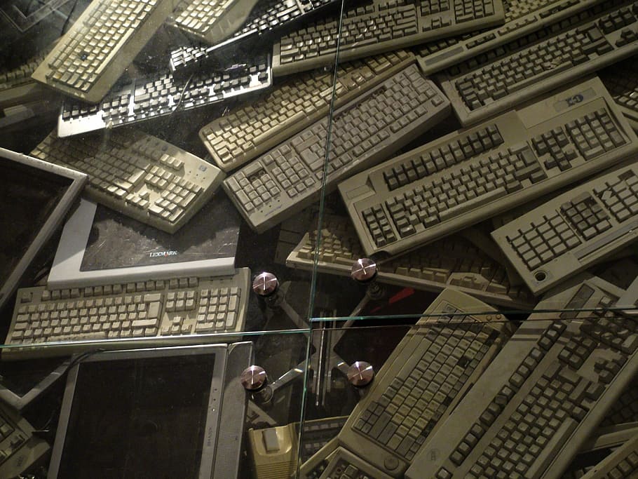 computer keyboards and screens piled up