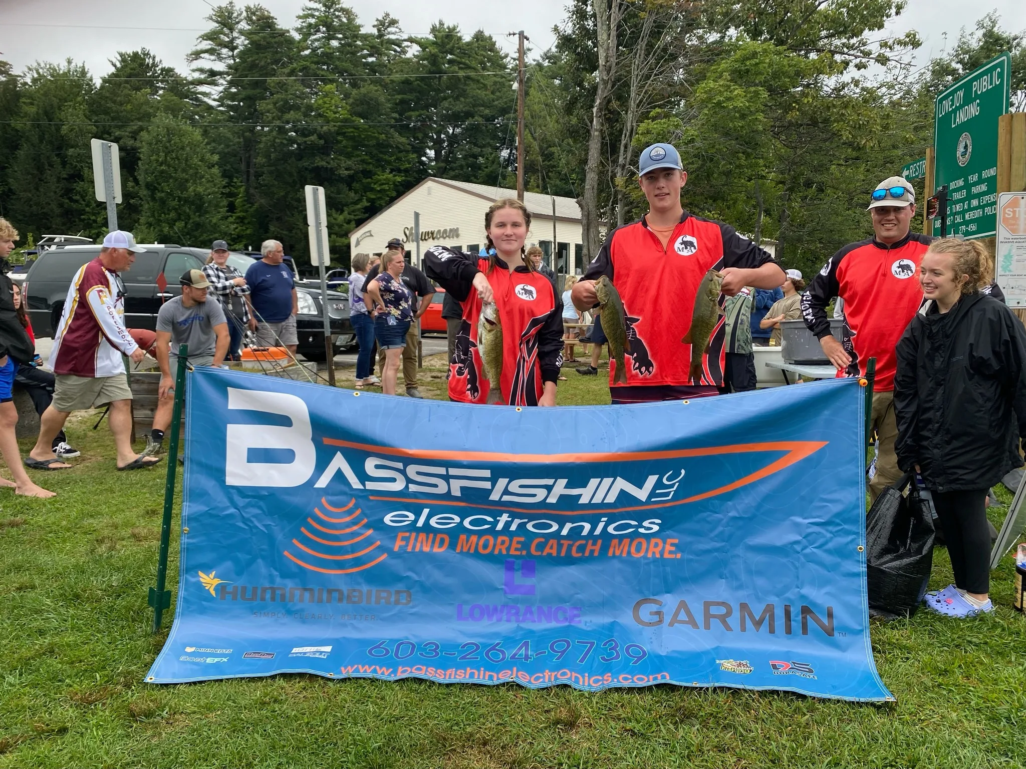 two people holding bass fish