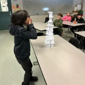 boy surprised how tall his paper tower is