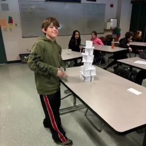 boy building paper tower